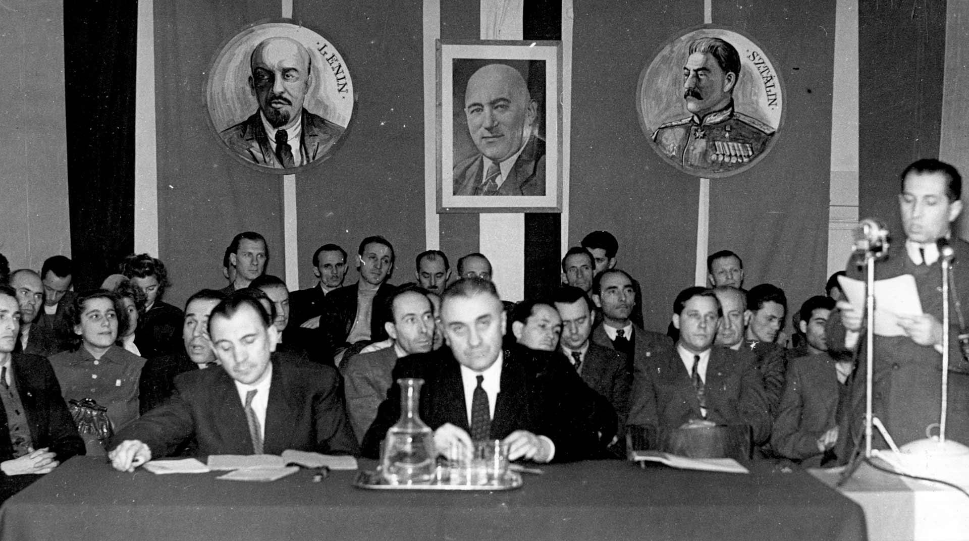 Levéltári kutatási eredmények 1956-ról - Tipikus rendezvénykép a Rákosi korszakból. Sztálin képe alatt a 2. sorban félig takarásban Hepp Ferenc.